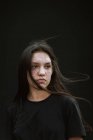 Anonymous trendy female standing on background of black wall of building in city in Costa Rica — Stock Photo