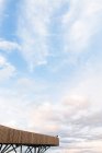 Vue à distance de la personne debout sur le point de vue en bois sur fond de ciel nuageux au coucher du soleil incroyable — Photo de stock