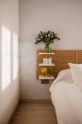 Increíble ramo de tulipanes y decoración cerca de la cama en una habitación luminosa y soleada - foto de stock