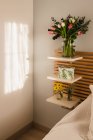 Sorprendente bouquet di tulipani e decorazione vicino al letto in una stanza luminosa e soleggiata — Foto stock