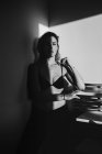 Tournage noir et blanc d'une jolie femme sensuelle jouant entre lumière et ombre en lingerie — Photo de stock