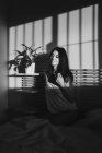Scatto in bianco e nero di una bella donna sensuale che gioca tra luce e ombra in lingerie — Foto stock
