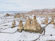 Malerischer Drohnenblick auf Steinformationen in verschneiter Landschaft an einem Wintertag in Kappadokien, Türkei — Stockfoto