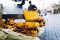 Costelas de milho cruas e fritas frescas dispostas na barraca do restaurante de rua contra panela fumegante na cidade na Turquia — Fotografia de Stock