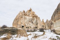 Сверху грунтовая дорога против снежного холма с известными колоннами с острыми пиками в форме копья в национальном парке Турции — стоковое фото