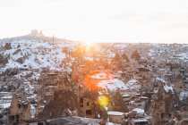 De acima do acordo famoso com edifícios de pedra antigos que sabem como casas de fadas no vale contra a colina nevada no dia ensolarado de inverno na Turquia — Fotografia de Stock