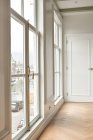 Длинный пустой коридор, оформленный в минималистичном стиле с окнами — стоковое фото
