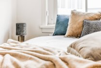 Интерьер спальни со стильной кроватью и подушками — стоковое фото