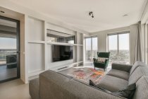 Una acogedora sala de estar con gran sofá elegante - foto de stock