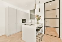 Cucina luminosa con un'isola di cucina di lusso nella casa elegante — Foto stock