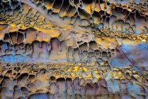 Текстура з золотими і синіми тонами еродованої скелі — стокове фото