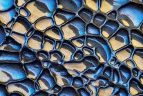 Fundo texturizado áspero de rocha sedimentar de cores azuis e amarelas com superfície desigual — Fotografia de Stock