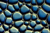 Sfondo ruvido strutturato di roccia sedimentaria di colori blu e giallo con superficie irregolare — Foto stock