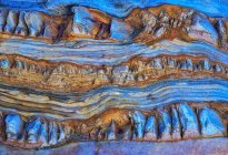 Fondo áspero texturizado de roca sedimentaria de colores azul y rosa con superficie desigual - foto de stock