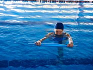D'en haut de nager anonyme femelle avec nouilles en mousse dans la piscine pendant la formation d'aérobic aquatique — Photo de stock
