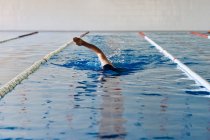Anonymous male swimming in crawl style in pool during training — Stock Photo