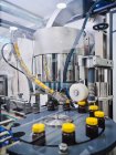 Bottiglie di plastica con medicina su trasportatore di tappatrice nel laboratorio di produzione farmaceutica — Foto stock