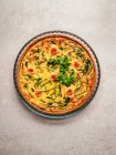 Top view of yummy quiche with fresh parsley and asparagus placed on table — Stock Photo