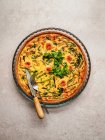 Top view of yummy quiche with fresh parsley and asparagus placed on table — Stock Photo