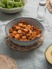 De arriba de frijoles fritos cubos de cuajada en cuenco sobre la mesa con tortillas y sal entre ingredientes frescos - foto de stock