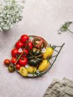 Вид зверху вегетаріанського томатного салату на тарілці на сірому бетонному столі — стокове фото