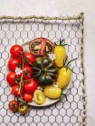 Вид зверху вегетаріанського томатного салату, який подається на тарілці в стійці на сірому бетонному столі — стокове фото