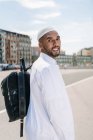 Homem islâmico em roupas brancas autênticas enquanto está de pé — Fotografia de Stock