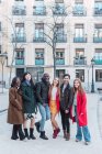 Empresa de amigos multirraciais felizes em roupas elegantes em pé na câmera juntos na rua da cidade durante o fim de semana — Fotografia de Stock