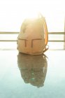 Traveling backpack placed on floor near window in departure lounge in modern airport — Stock Photo