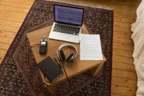 Сверху магнитофон и наушники, размещенные на деревянном столе с ноутбуком и ноутбуком для записи подкаста дома — стоковое фото