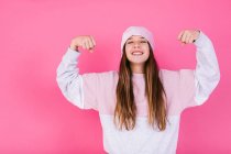 Conteúdo adolescente do sexo feminino em roupa casual e lenço de cabeça para conceito de câncer demonstrando braços fortes enquanto olha para a câmera com sorriso de dente — Fotografia de Stock