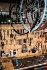 Par en bas des jantes de vélo brillantes métalliques suspendues sur le rack dans le service de réparation — Photo de stock