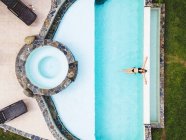 Frau von oben allein im Schwimmbad und genießt einen sonnigen Sommertag — Stockfoto