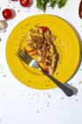 Leckeres Omelett mit gehackter Petersilie auf Teller gegen sonnengetrocknete Tomaten auf weißem Hintergrund — Stockfoto