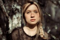 Портрет молодої красивої блондинки в лісі, драматичне освітлення її обличчя — стокове фото