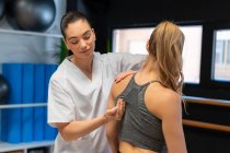Weibliche Osteopathin passt Schultergelenk von Patientin bei Schmerzen während Physiotherapie-Sitzung an — Stockfoto