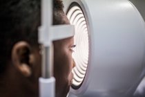 Black woman in optometry cabinet during study of the eyesight using a modern corneal topographer — Stock Photo