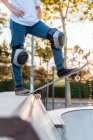 Кукурудзяний підліток ковзаняр стоїть на скейтборді і готується до показу трюку на пандусі в скейт-парку — стокове фото