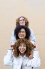 Diverse man and women standing behind each other showing heads with curly hair and laughing — Stock Photo
