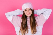 Content female teenager in casual outfit and headscarf for cancer concept demonstrating strong arms while looking at camera with toothy smile — Stock Photo