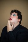 Чувственный трансгендер с избыточным весом мужчины с ярким макияжем касаясь красных губ и открывая рот — стоковое фото