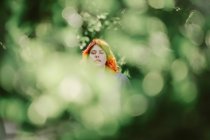 Мрійлива руда жінка охолоджує в зеленому парку і насолоджується літніми вихідними з закритими очима — стокове фото