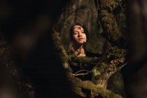 Ritratto di giovane bella donna bionda in una foresta, illuminazione drammatica sul suo viso — Foto stock