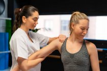 Weibliche Osteopathin passt Schultergelenk der Patientin bei Schmerzen während der Physiotherapie an — Stockfoto