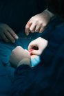 Ernte anonymer Tierarzt in Latex-Handschuhen mit chirurgischen Werkzeugen, die Operation an der Pfote des Tieres mit sterilen Lochtuch in Tierklinik bedeckt — Stockfoto