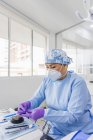 Stomatologin in Uniform und steriler Maske bereitet am Tisch im Krankenhaus tagsüber zahnärztliche Werkzeuge vor — Stockfoto