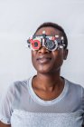 Mulher negra feliz no gabinete de optometria durante o estudo da visão — Fotografia de Stock