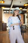 Giovane donna sorridente in abbigliamento elegante con cellulare in mensa con lampade — Foto stock