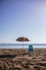 Landscape view of umbrella and chair placed on sand at the beach on a summer day — Stock Photo