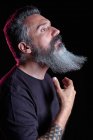 Вид на красивый зрелый мужчина с седой бородой на черном фоне в студии — стоковое фото